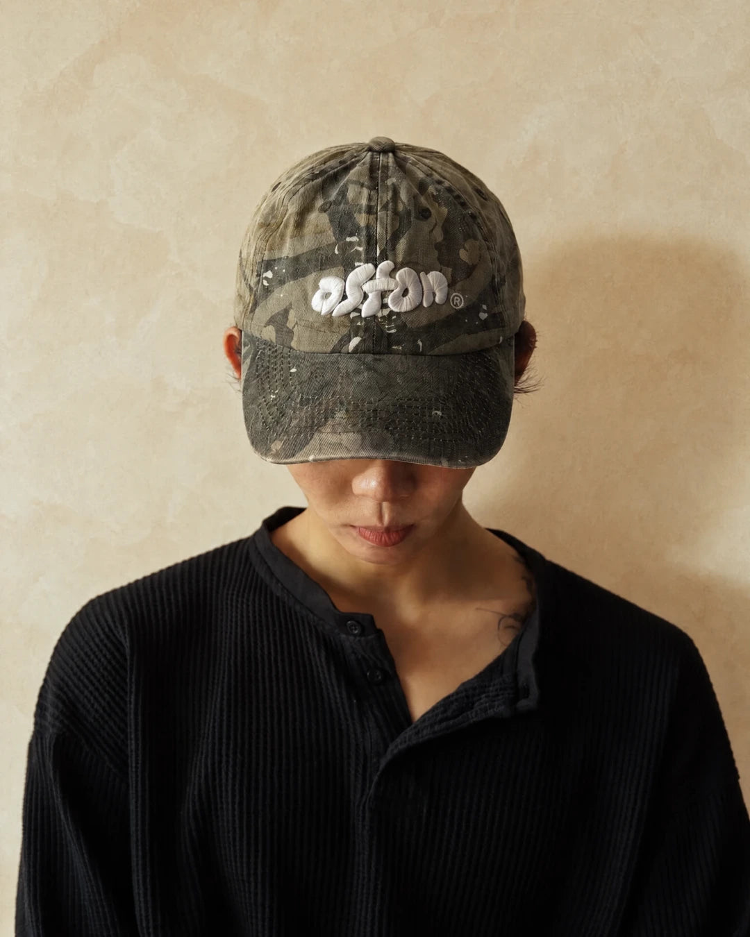 Staple Cap Real Tree worn on model, front view, head bowed to show the puffed aston logo